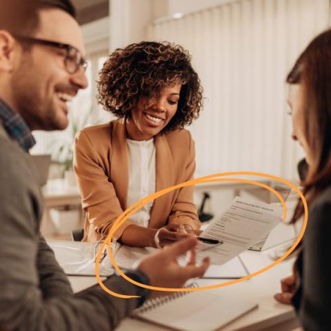 Trois personnes vêtues de façon professionnelle travaillant dans un bureau.