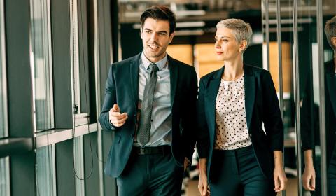 Two business directors walking in hallway of office