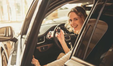 woman behind the wheel of a car keys in hand