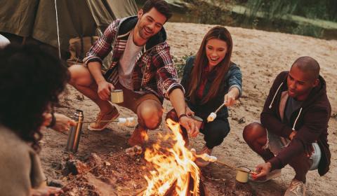 Campers roasting food on fire