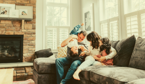 Young family playful on couch in home